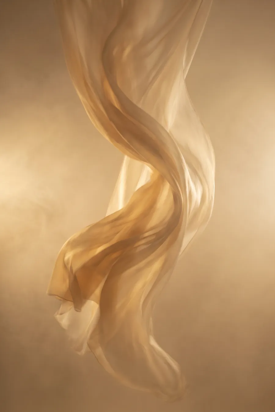 A furl of amber silk suspended in golden light